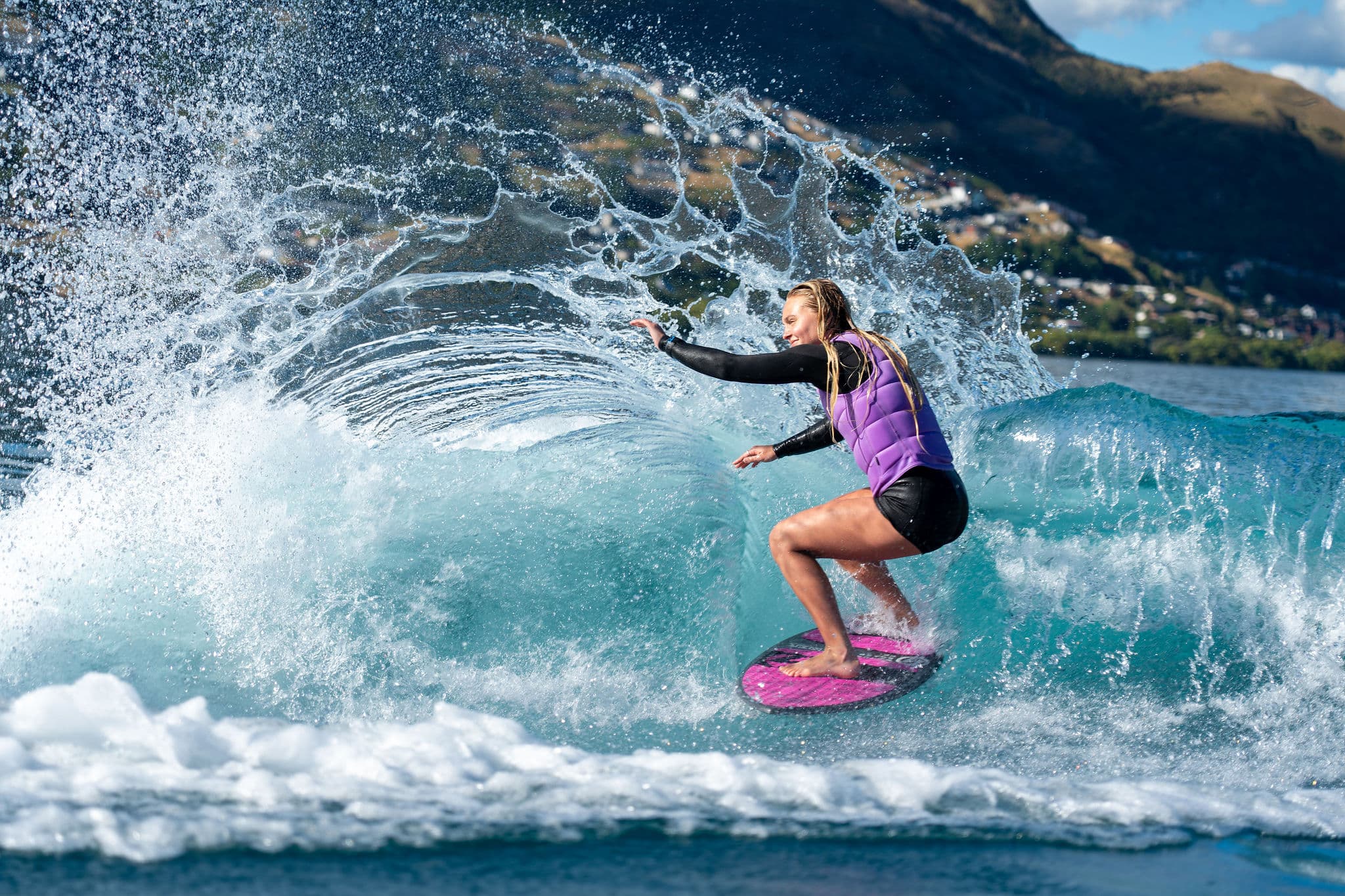 Hard carve off the top with spray flying — the speed every advanced trick is built on
